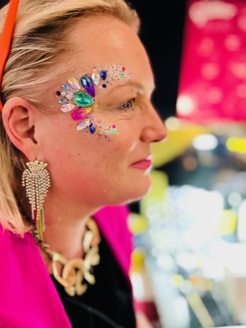 lady with glitter and festival gems on her face at a party